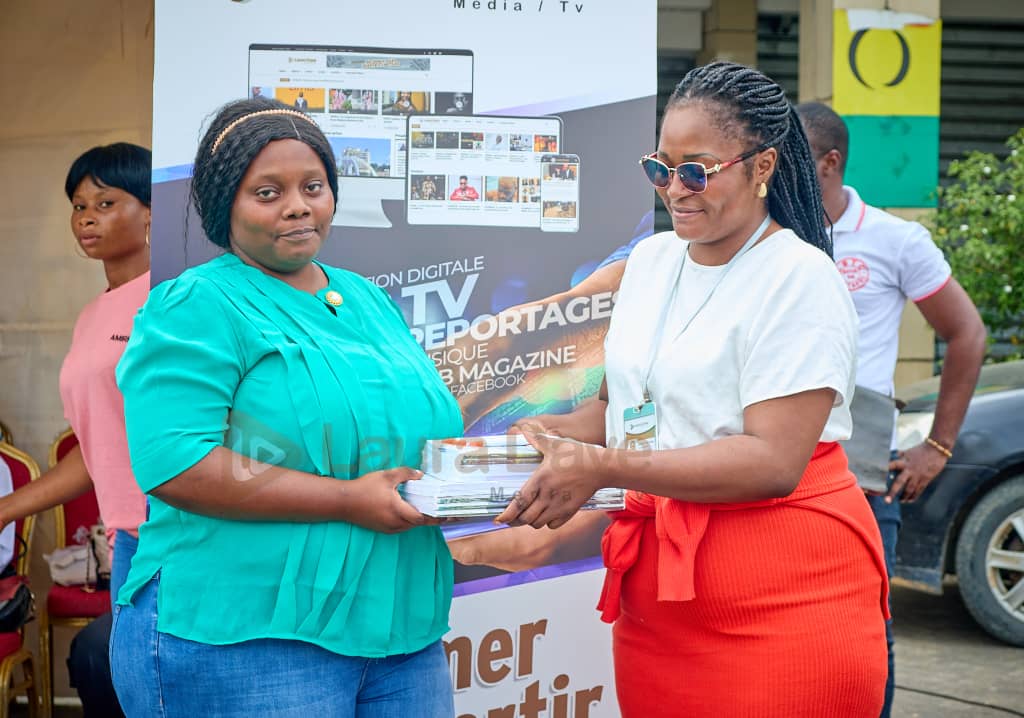 Enfants recevant des cahiers lors de la rentrée scolaire 2025 à Douala avec Laura Dave Media